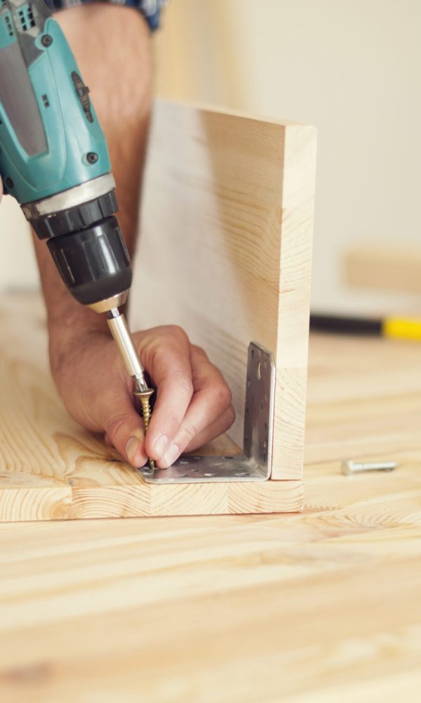 Close up of carpenter working with drill